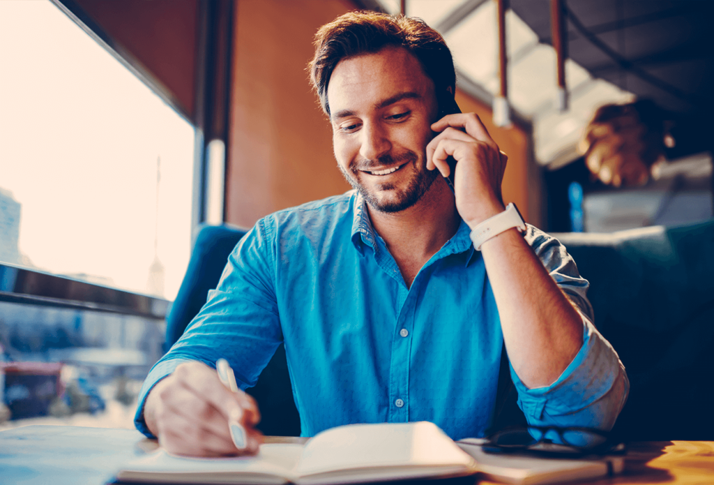 hombre feliz mirando un libro con los resultados de educación financiera